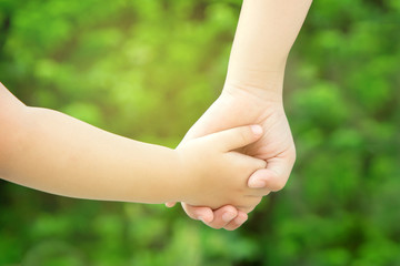 Older sister holding younger sister hands