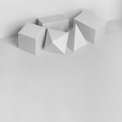 Platonic solids figures geometry. Abstract white color geometrical figures still life composition. Three-dimensional prism pyramid rectangular cube objects on gray background