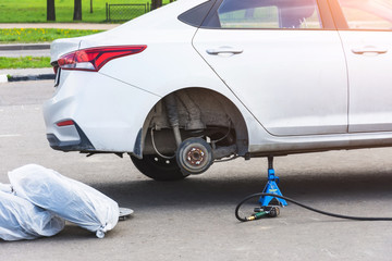 Replacing tires on wheels, a car without a rear wheel on a jack, express service maintenance.