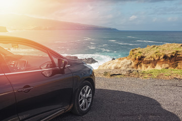 Car standing near the ocean with beautiful view on sunny day.