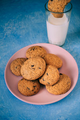 Homemade chocolate cookies on pink plate and blue background.