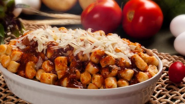 Portion of gnocchi in tomato sauce with cheese with smoke.