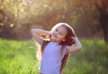 little girl dancing in nature in summer with long hair