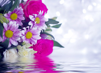 Spring bouquet of flowers close-up. Reflection in water. Light abstract floral background with bokeh