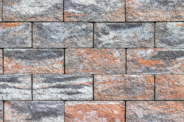 A wall of rough multicolored bricks background. Stone fence texture