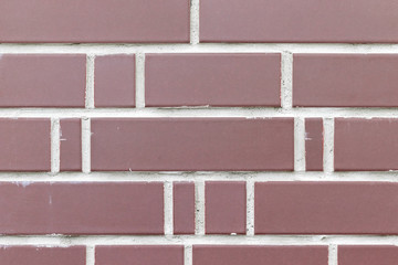 Obraz premium Smooth red decorative brick wall with white cement grout between them. Brick fence background texture