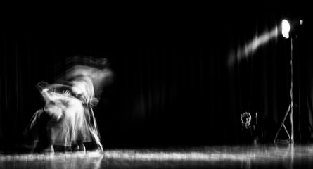 An artistic dancer in a theater shot with a slow shutter speed in order to achieve the desired motion blur. - obrazy, fototapety, plakaty