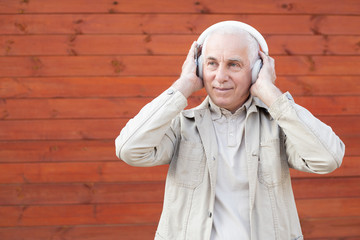 Attractive middle-aged man listening to music on stereo headphones, successful businessman.