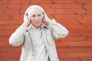 Senior man in headphones is listening to music, successful senior businessman.