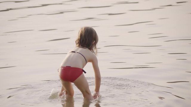 Little girl wearing bikini in shallow water