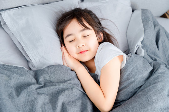 Asian little girl sleeping in bed