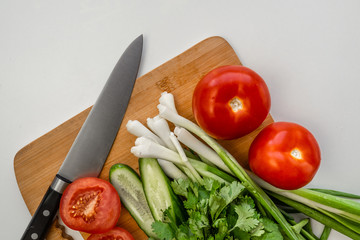 Fresh green onions, parsley lie on the table for the preparation of the salad