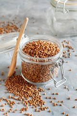 Raw dry buckwheat grain  in a jar with a spoon