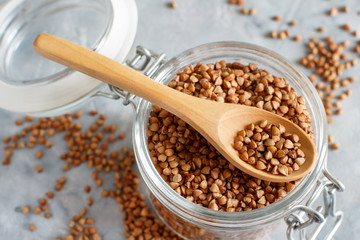 Raw dry buckwheat grain  in a jar with a spoon