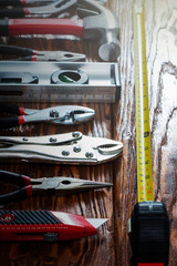 Close-up of hand tools on a wooden background.