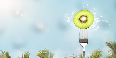 Fresh kiwi fruit on a fork panorama