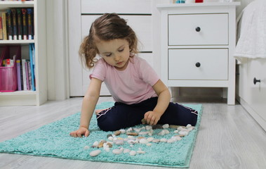 A child plays with pebbles. Concept of development and training of a child at home. A favorable...