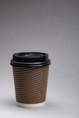 paper cup with coffee cappuccino on grey background Close up