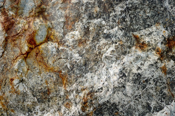 rough irregular surface of natural white and gray rock from a wall with abstract orange shapes and the cross symbol - background texture of a stone