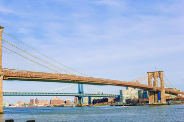 Brooklyn Bridge over river viewed from New York City.