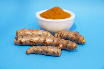 Picture of Turmeric root and turmeric powder on a blue background
