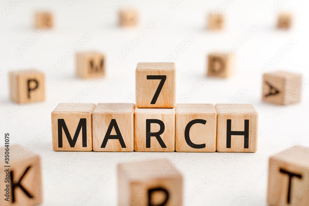 Poster march 7 - from wooden blocks with letters, important date concept, white background random letters a