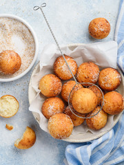 Cottage cheese donuts balls with sugar in a bowl on a blue background. Healthy curd dessert.  Top...