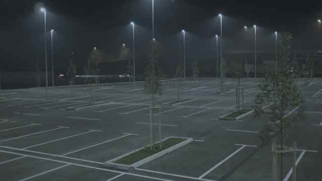 Aerial Lifting Shot Of An Empty Parking Lot In The Middle Of The Night