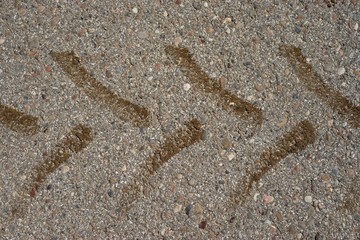 Traktorspuren aus Erde auf Asphalt