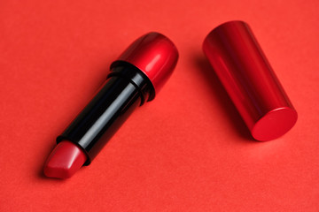 Cosmetic lipstick red lips on a red background.