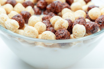 Breakfast cereal white chocolate balls close-up selective focus in milk background.