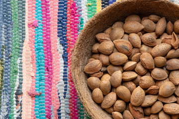 Cesta de almendras sobre confección de colores