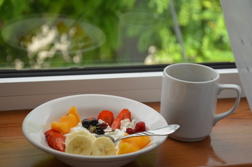 Healthy breakfast or snack curd with fruit and nuts. The concept of nutrition for weight loss. Keto breakfast. Keto lunch idea. cottage cheese or yogurt with berries on a window cup of coffee or tea