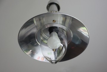 one gray metal chandelier with a white light on the ceiling in the room