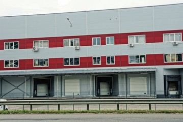 a row of garages in a gray red large building with windows