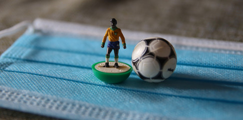 Brazilian plastic football player with ball and surgical mask for Coronavirus Prevention - Covid19 pandemic