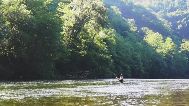 fly trout fisherman in big river