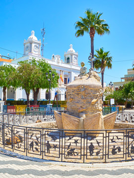 Barbate, Spain - June 25, 2019. Monument statue to the Fisherman with the Barbate Town Hall in the background. Plaza De La Inmaculada Square. Barbate, Andalusia, Spain.
