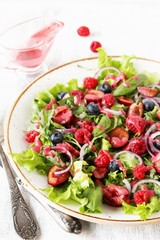 Salad with berries-raspberry, blueberry, sweet cherry. Dressed with raspberry vinaigrette. Soft focus. copy space