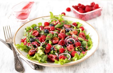 Salad with berries-raspberry, blueberry, sweet cherry. Dressed with raspberry vinaigrette. Soft focus. copy space