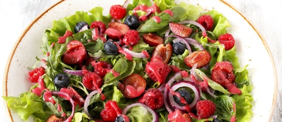 Salad with berries-raspberry, blueberry, sweet cherry. Dressed with raspberry vinaigrette. Soft focus. copy space
