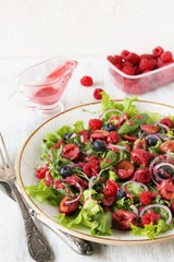 Salad with berries-raspberry, blueberry, sweet cherry. Dressed with raspberry vinaigrette. Soft focus. copy space