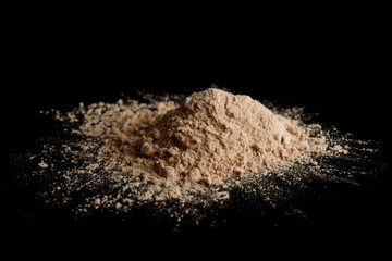 Spilled brown powder looking like unrefined heroin, isolated