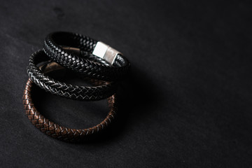 leather and silver bracelets on black background. Lifestyle and men bracelets.