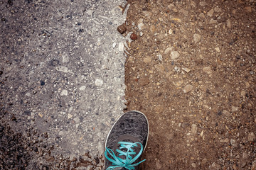 Zapatilla sobre suelo mitad naranja terreno, mitad charco