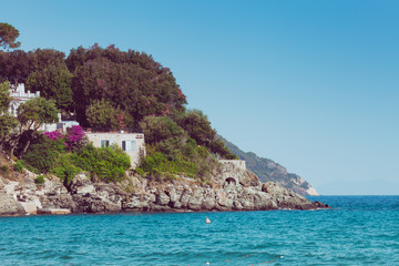 Italian maritime coast of the Island of Elba with rocky ridge and perched house. Sea, trees and rocks in Italy in the city of Procchio.