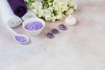 Fototapeta na wymiar towels, candle, salt, a bouquet of freesia and stones - items for a spa procedure