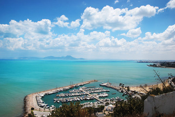 The view from the heights of the marina, azure sea, mountains and blue sky. Harbor Sidi Bou Said