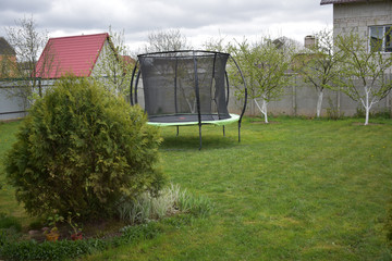 Trampoline on a green lawn.