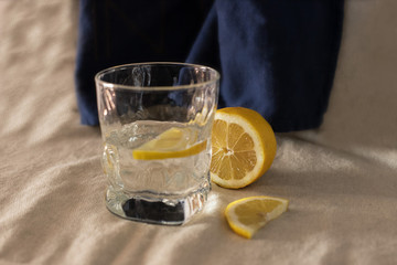 Glass of water with lemon on a blue background